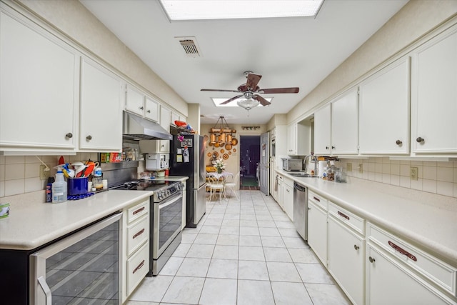 kitchen with white cabinets, stainless steel appliances, wine cooler, and tasteful backsplash