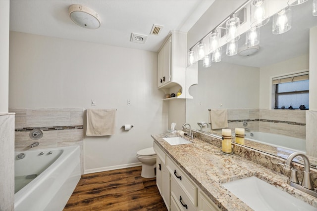 bathroom featuring wood-type flooring, vanity, toilet, and a tub