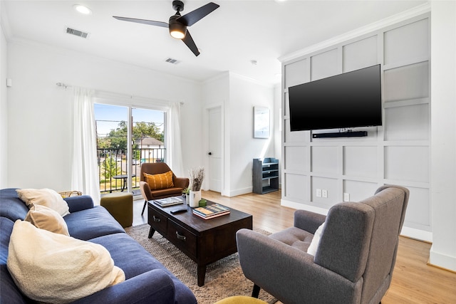 living room with ceiling fan, crown molding, and light hardwood / wood-style flooring