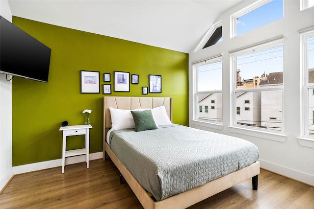 bedroom featuring hardwood / wood-style flooring and vaulted ceiling