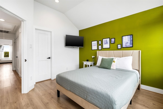 bedroom featuring light hardwood / wood-style floors and vaulted ceiling