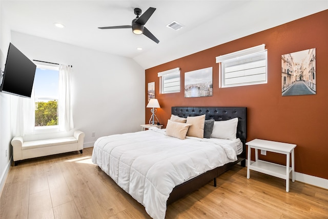 bedroom featuring ceiling fan, light hardwood / wood-style floors, and vaulted ceiling