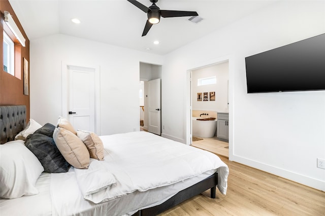 bedroom featuring connected bathroom, ceiling fan, light hardwood / wood-style flooring, and vaulted ceiling