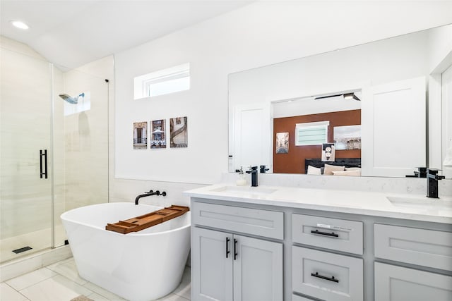 bathroom featuring tile patterned flooring, vanity, independent shower and bath, and vaulted ceiling