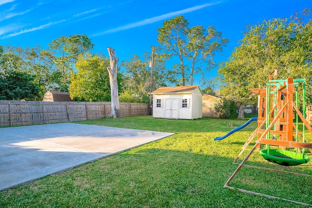 view of yard featuring a playground, a patio, and a storage unit