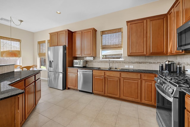 kitchen featuring hanging light fixtures, plenty of natural light, stainless steel appliances, and sink