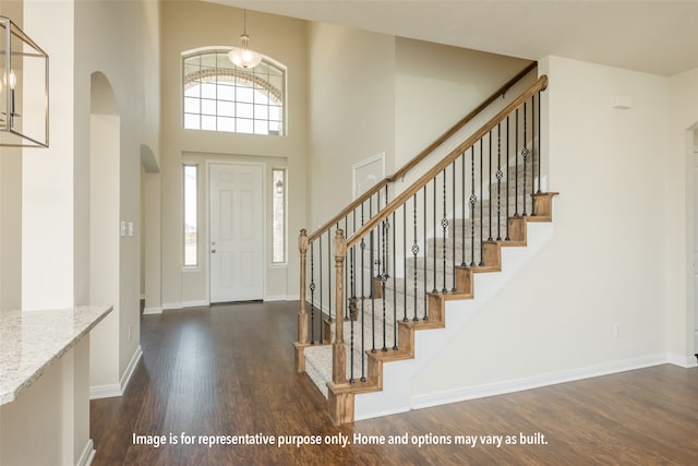 entryway with dark wood-type flooring and a high ceiling