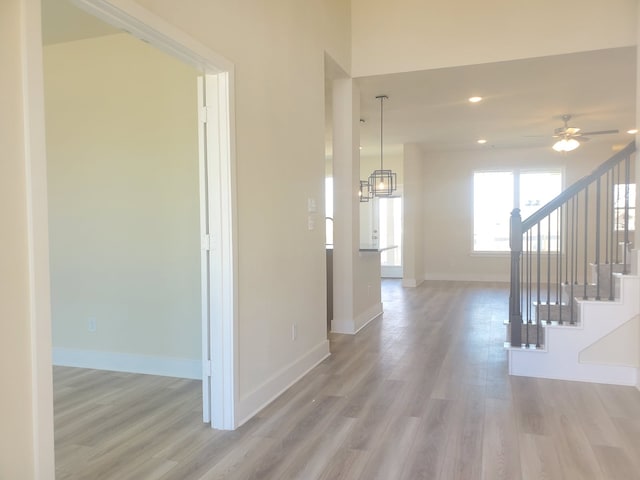 interior space featuring recessed lighting, light wood-style flooring, baseboards, and stairs