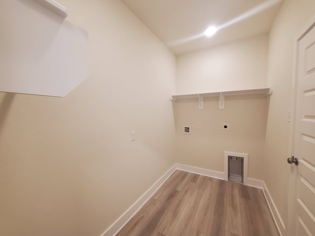 clothes washing area featuring baseboards, laundry area, light wood-type flooring, and hookup for an electric dryer