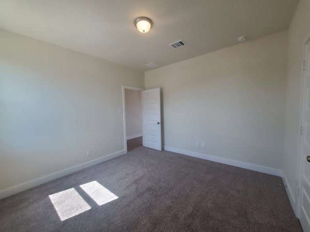 unfurnished room featuring carpet, visible vents, and baseboards