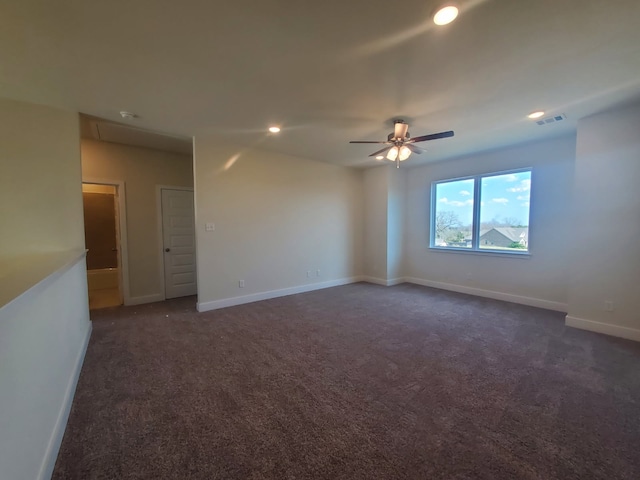 unfurnished room featuring visible vents, dark carpet, and baseboards