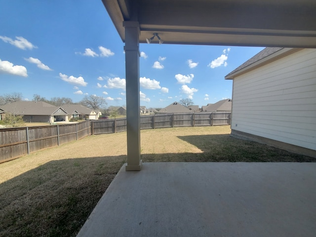 view of yard featuring a fenced backyard, a residential view, and a patio