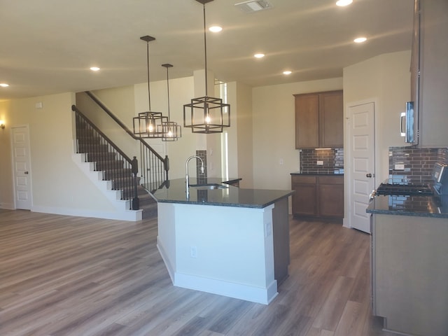 kitchen featuring visible vents, stainless steel microwave, dark wood-style flooring, a sink, and recessed lighting