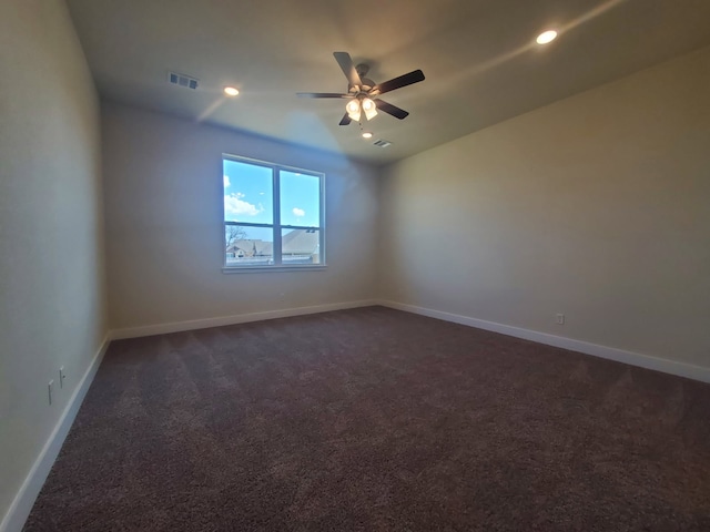 empty room with recessed lighting, dark carpet, visible vents, and baseboards