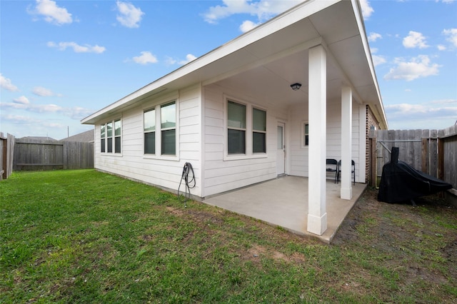 back of house with a patio area and a yard