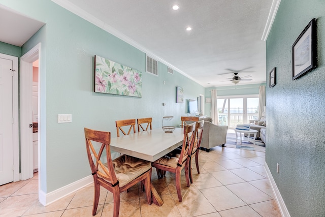 tiled dining room featuring crown molding and ceiling fan