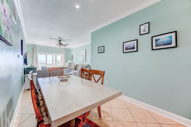 tiled dining room with crown molding and ceiling fan