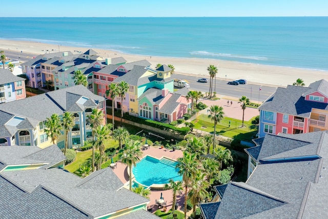 birds eye view of property featuring a water view and a beach view