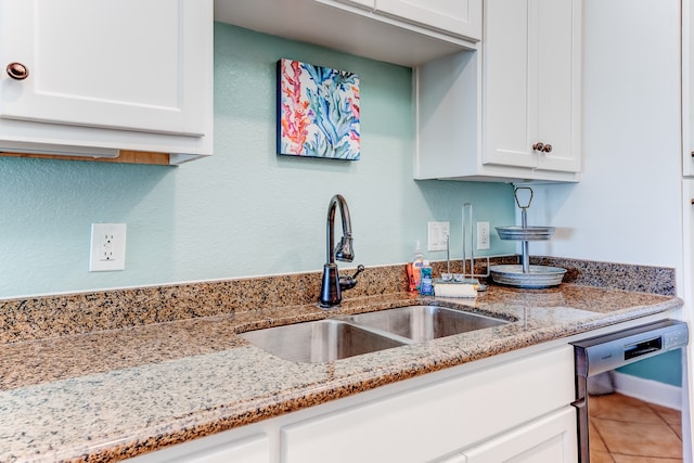 kitchen featuring white cabinets, tile patterned flooring, sink, and black dishwasher