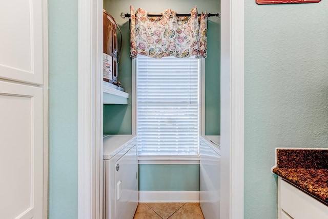 clothes washing area featuring washer and clothes dryer and light tile patterned floors