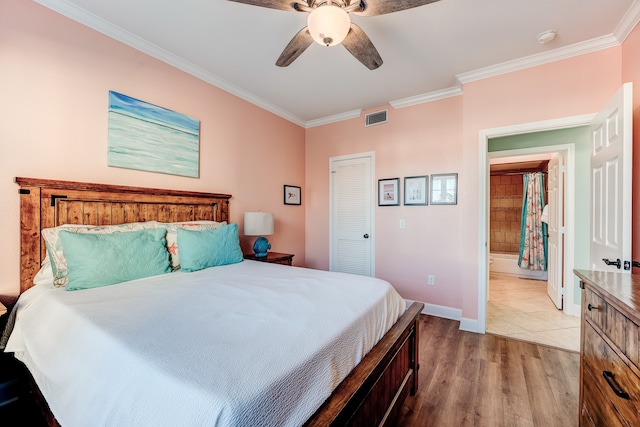 bedroom featuring ensuite bathroom, crown molding, ceiling fan, light hardwood / wood-style floors, and a closet