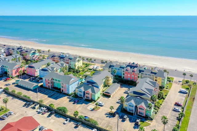 birds eye view of property with a water view and a beach view