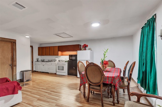 dining space featuring sink and light hardwood / wood-style floors