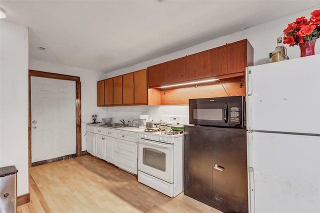 kitchen with white appliances, light hardwood / wood-style flooring, and sink