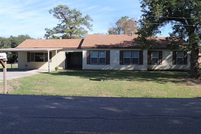 ranch-style home featuring a carport and a front lawn