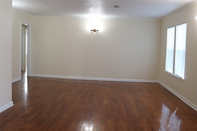 empty room featuring dark wood-type flooring, a healthy amount of sunlight, and ornamental molding