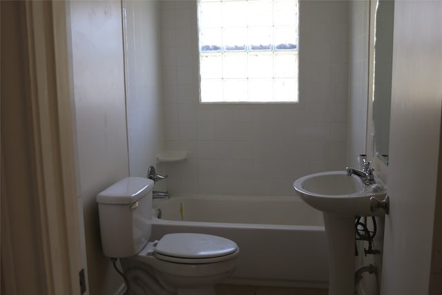 bathroom with tiled shower / bath combo and toilet