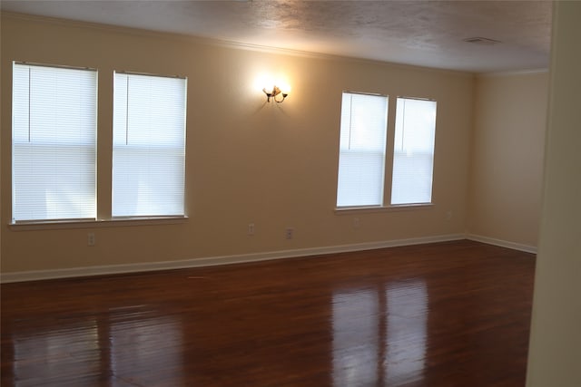 empty room with crown molding, dark hardwood / wood-style flooring, and a textured ceiling