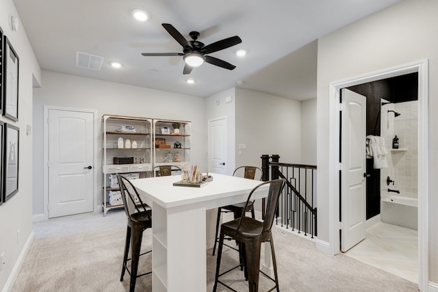 dining room with light carpet and ceiling fan