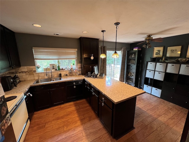 kitchen with kitchen peninsula, light hardwood / wood-style flooring, white electric range oven, and sink