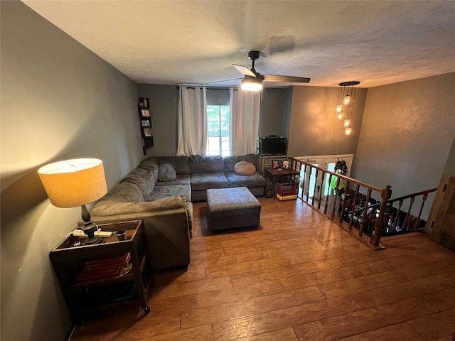 living room with hardwood / wood-style floors, a textured ceiling, and ceiling fan