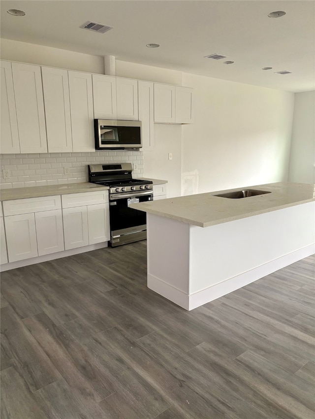 kitchen with sink, white cabinets, dark hardwood / wood-style floors, and appliances with stainless steel finishes