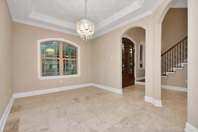 spare room with a raised ceiling, crown molding, and an inviting chandelier