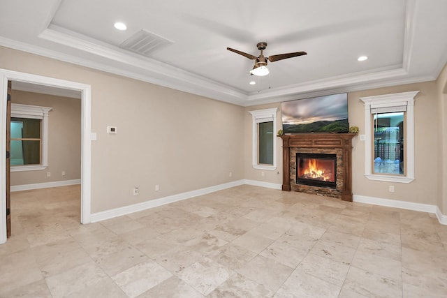 unfurnished living room with ceiling fan, a raised ceiling, ornamental molding, and a fireplace