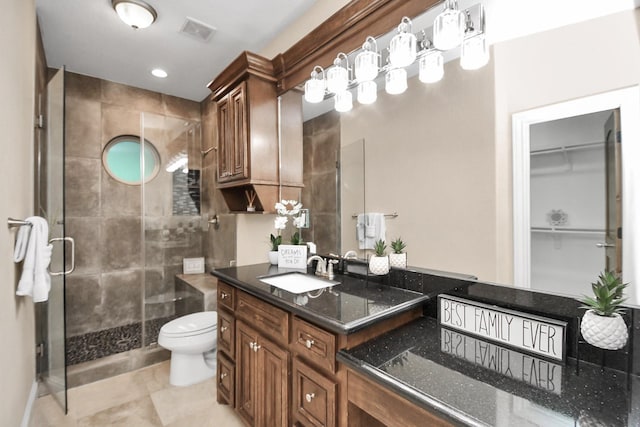 bathroom with tile patterned floors, vanity, toilet, and walk in shower