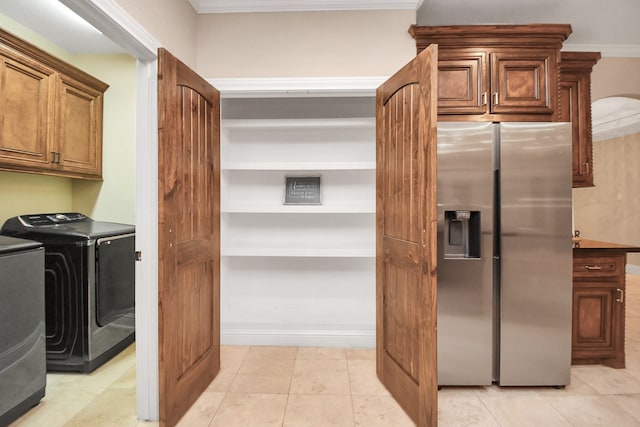 interior space with stainless steel fridge, separate washer and dryer, crown molding, and light tile patterned floors