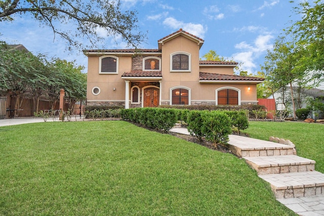 mediterranean / spanish house featuring a front yard