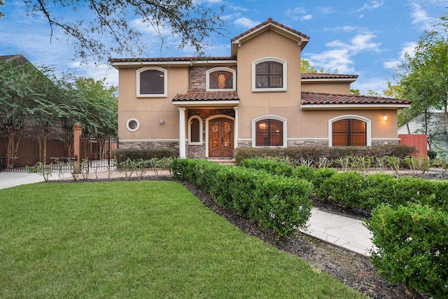 mediterranean / spanish-style home with a front yard