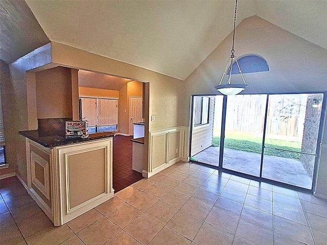 kitchen with vaulted ceiling, light tile patterned floors, and hanging light fixtures