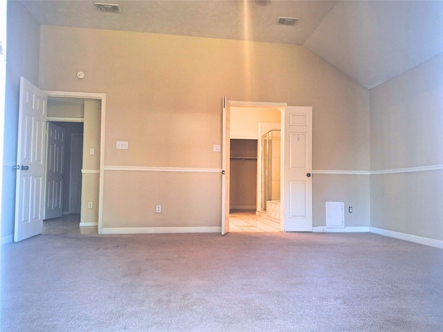 empty room with lofted ceiling and light colored carpet