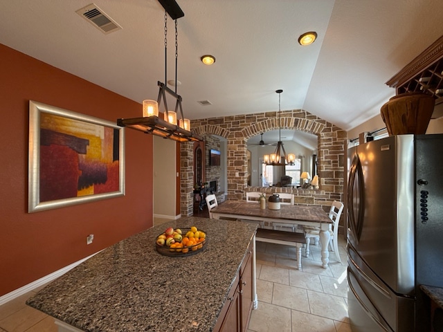 kitchen with stainless steel fridge, decorative light fixtures, a chandelier, a center island, and lofted ceiling