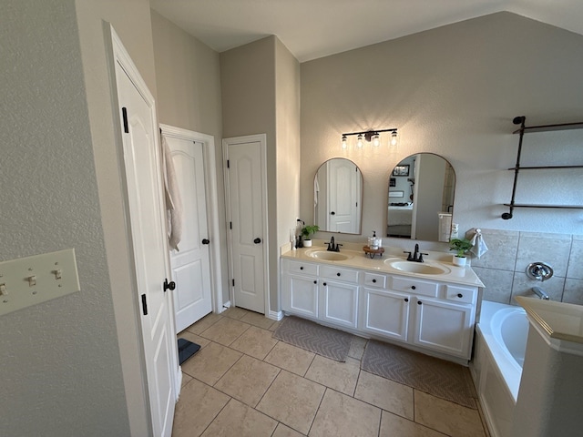 bathroom with tile patterned flooring, vanity, and a washtub