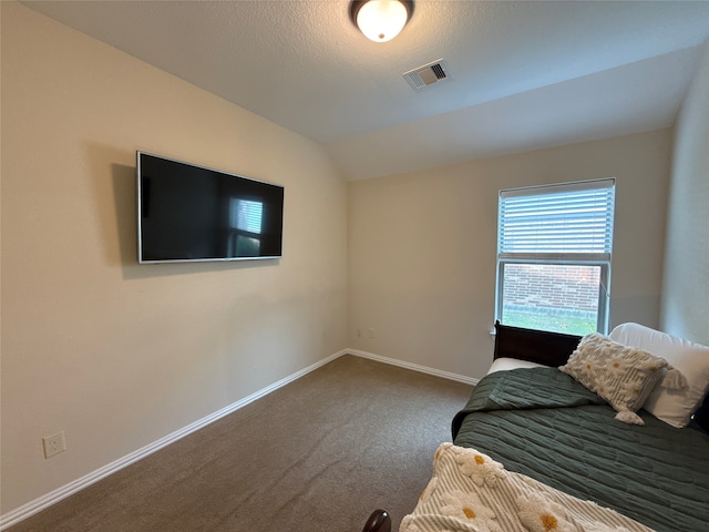 unfurnished bedroom featuring carpet, a textured ceiling, and lofted ceiling