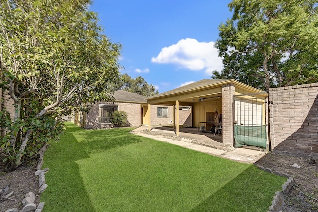 back of house with a yard and a patio