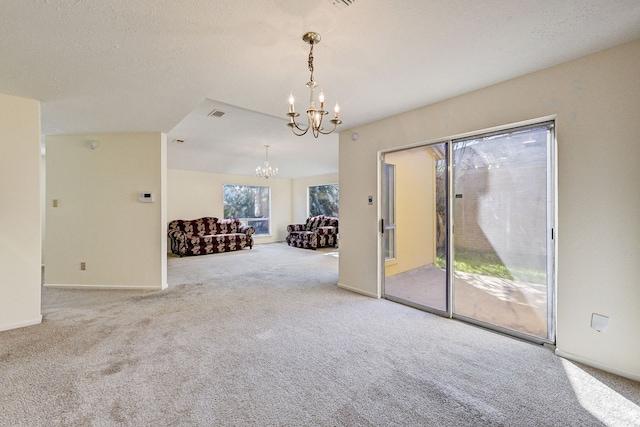 unfurnished room featuring carpet flooring, a chandelier, and a textured ceiling