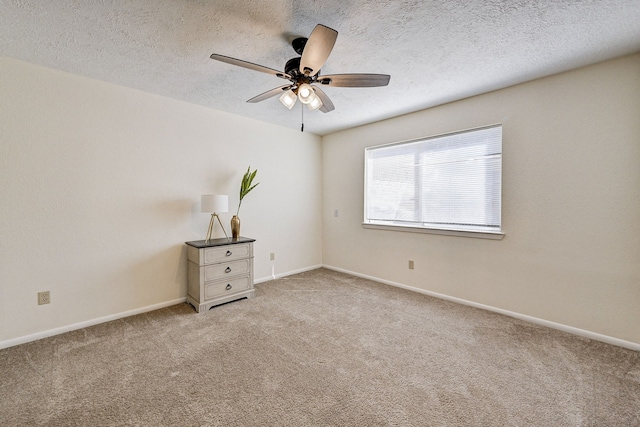 carpeted spare room featuring a textured ceiling and ceiling fan